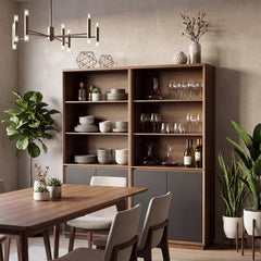 A dining room with a tall open wooden cabinet displaying dishes, wine glasses and bottles, beside a dining table, chairs, plants and a hanging chandelier.