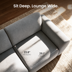 Overhead view of a gray upholstered sofa seat with dashed measurement lines labeled 23.8 inches (60.5 cm) and 29.1 inches (74 cm).