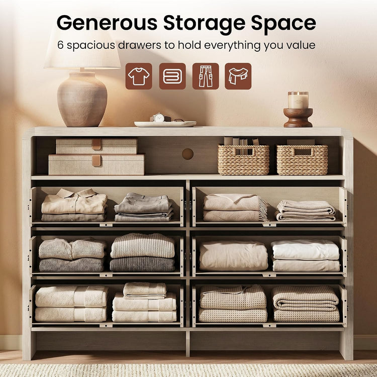 Wide pale storage chest shown open with six compartments filled with folded clothing and linens