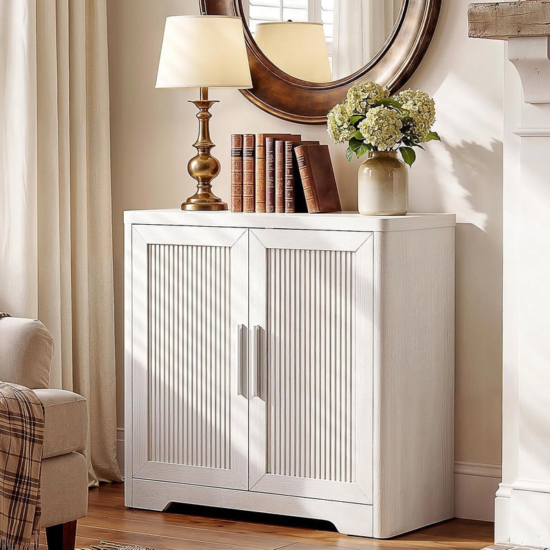 White wood cabinet with two reeded doors in a styled living room.