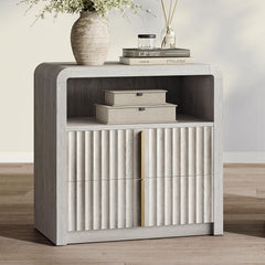 Pale wood-grain nightstand with rounded corners, an open cubby and two fluted drawers with vertical gold-tone pulls