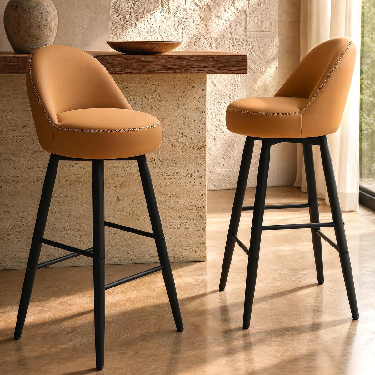 Two tan upholstered stools with curved backs and dark footrest frames stand beside a counter