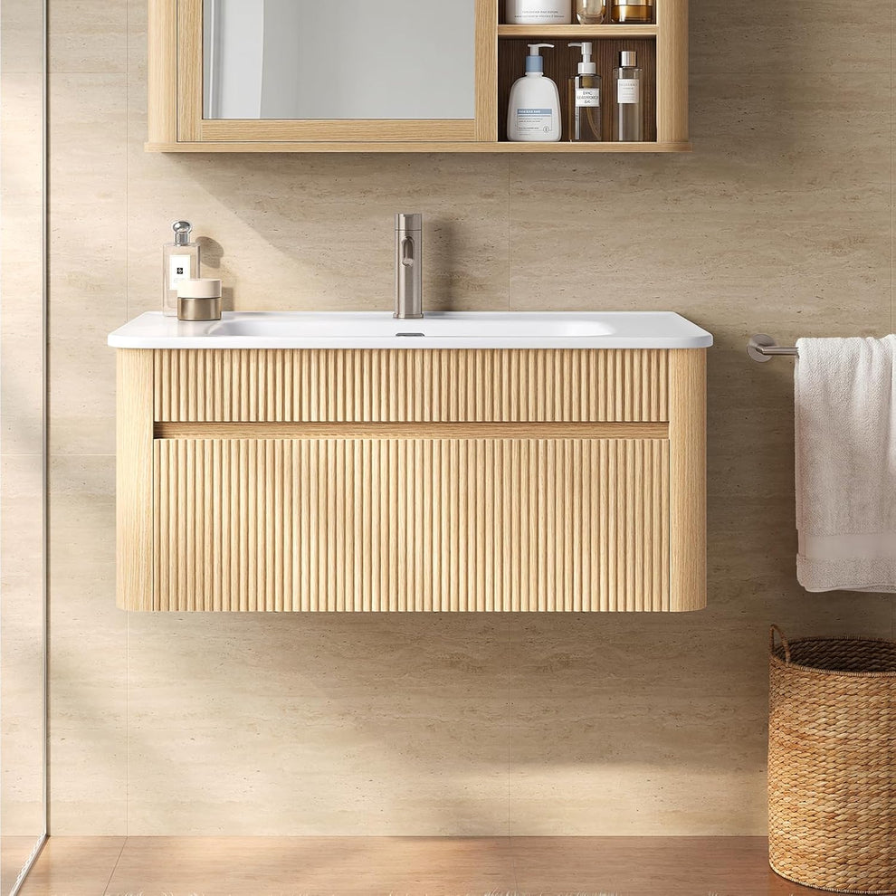 Floating light wood-tone bathroom vanity with a fluted front and white sink beneath a mirrored cabinet