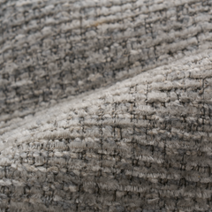 Close-up of a fuzzy, looped gray-beige woven textile with rows of raised stitching.