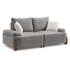 A gray two-seat sofa with broad cushions, brown legs, and two white textured pillows against a white background.