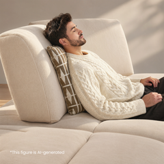 Man resting with eyes closed on a cream sectional sofa.