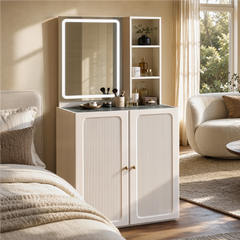 Illuminated mirror stands above a white two-door cabinet, Three open shelves hold bottles and a vase