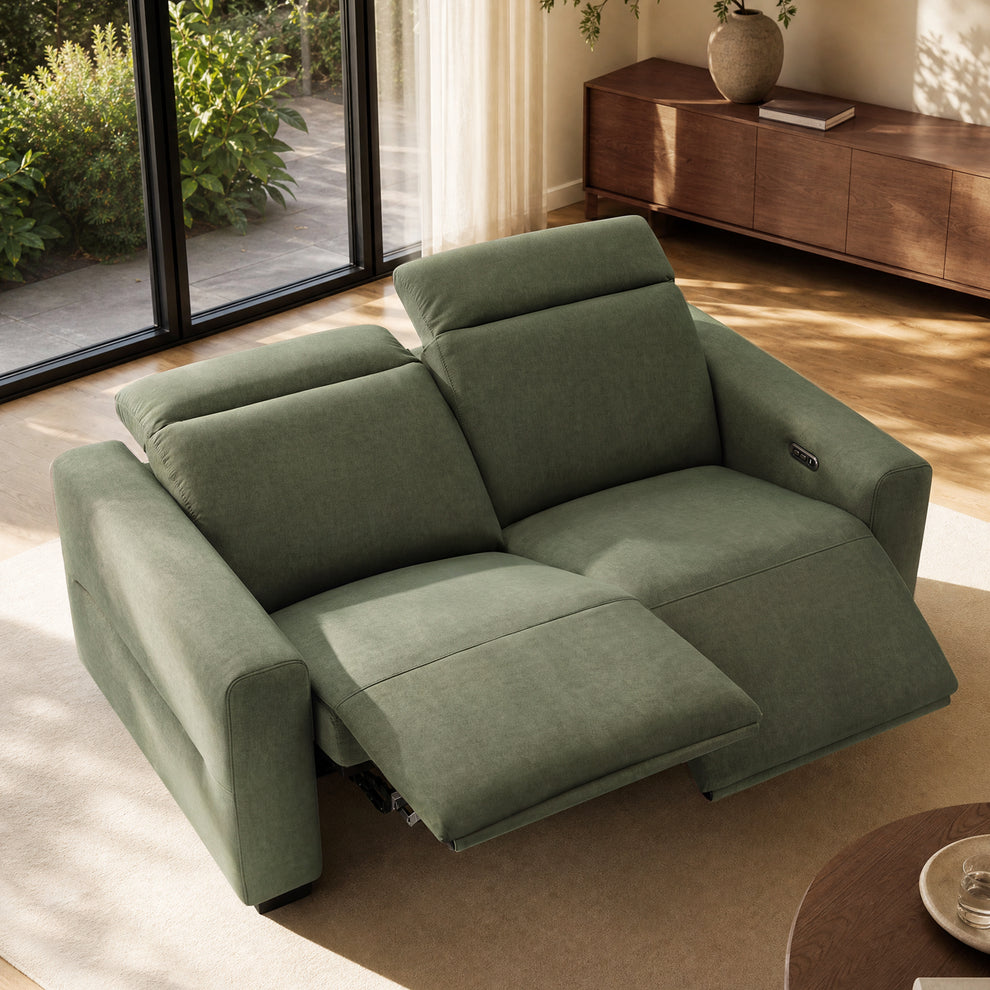 Green upholstered two-seat reclining sofa with raised footrests and adjustable headrests.