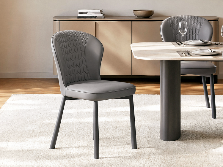 Two gray dining chairs have rounded backs with geometric stitching, Dark tapered legs support each chair