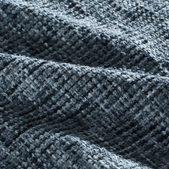 A blue-gray woven surface forms deep folds and shows a coarse multitone texture