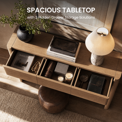 Three open drawers span a wood-grain console beneath a decorated tabletop, A lamp, vase, books, and tray sit above