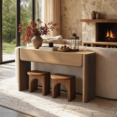 Light wood-grain console table with three drawers stands above two arch-shaped stools