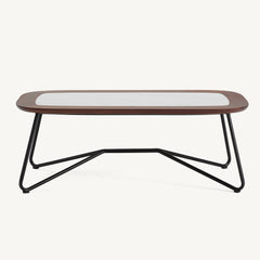 Long low coffee table has a pale veined inset, dark rounded frame, and crossed tubular legs