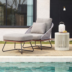 Gray cushioned lounge chair and small table beside a pool