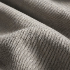 Pale gray fabric shows dense knitted loops across several softly draped folds
