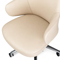 Close-up of a cream upholstered chair with a curved seat and back, stitched seams, padded armrests, and a metal wheeled base.
