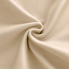 Close-up of a cream-colored surface with a fine pebbled texture, gathered into curved folds around a central swirl.
