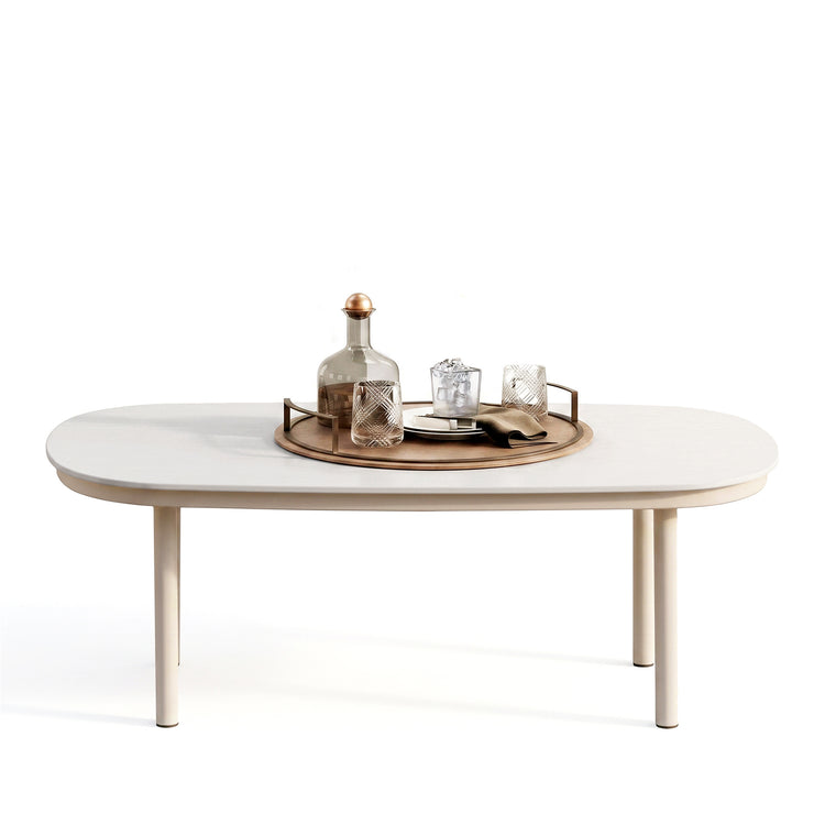 The table has a rounded rectangular top, Place settings and a tray rest on top