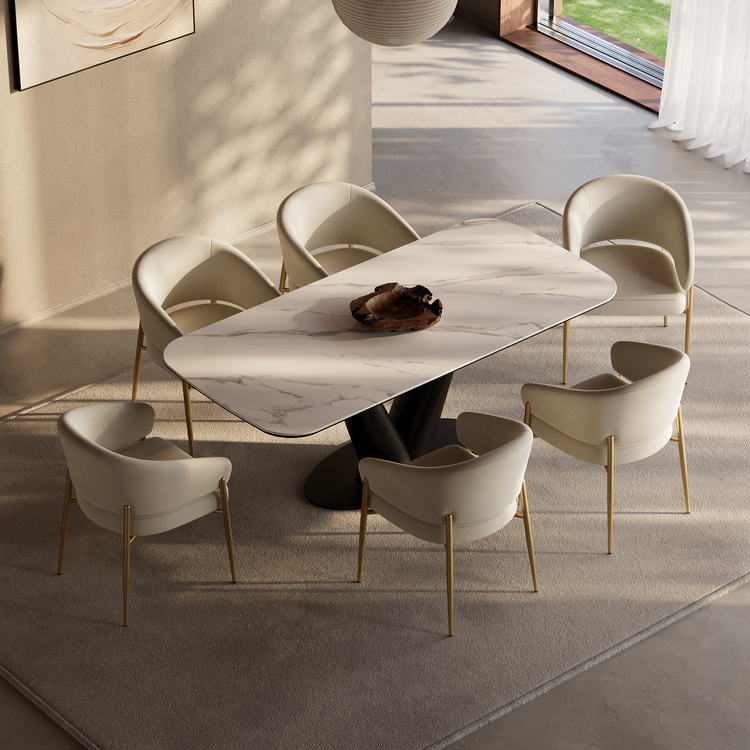 Rectangular marble-patterned dining table surrounded by six cream chairs with gold-tone legs