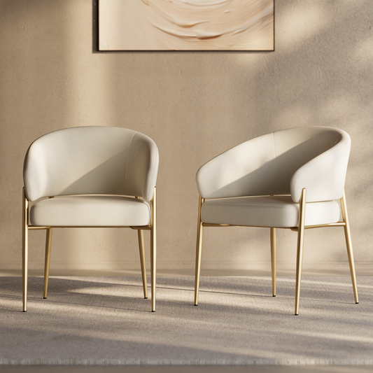 Two cream upholstered accent chairs with curved backs and gold-tone metal legs.