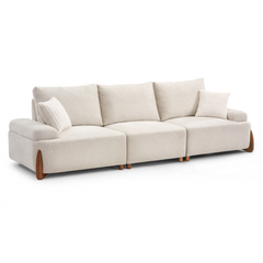 A cream-colored sectional sofa with three seat cushions, three back cushions, two throw pillows, and brown feet against a white background.