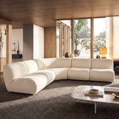 Cream modular sectional sofa has rounded cushions and an L-shaped arrangement