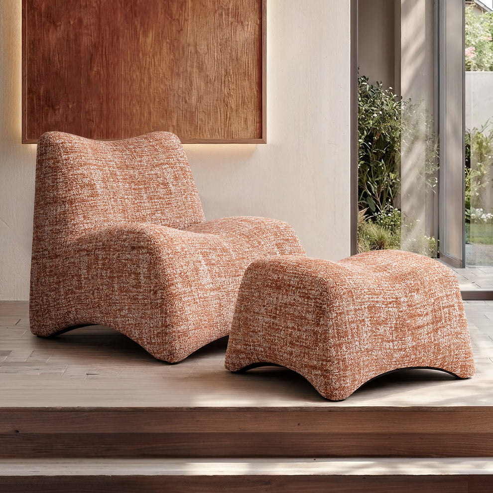 Orange sculptural lounge chair with matching ottoman in a modern room