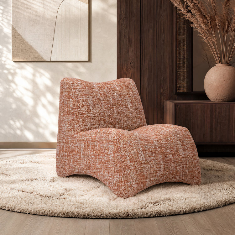 Rust-and-cream patterned lounge chair sits on a shag rug in a wood-paneled room