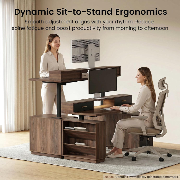 Two women demonstrate a sit-to-stand desk setup: one stands at the raised workstation while the other sits at a lower desk with a monitor and keyboard.