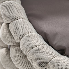 Macro close-up of a pale woven cord furniture frame beside a gray fabric cushion
