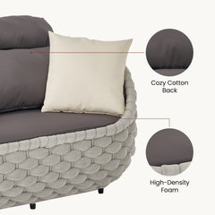Close-up shows dark cushions inside a pale basket-woven sofa frame