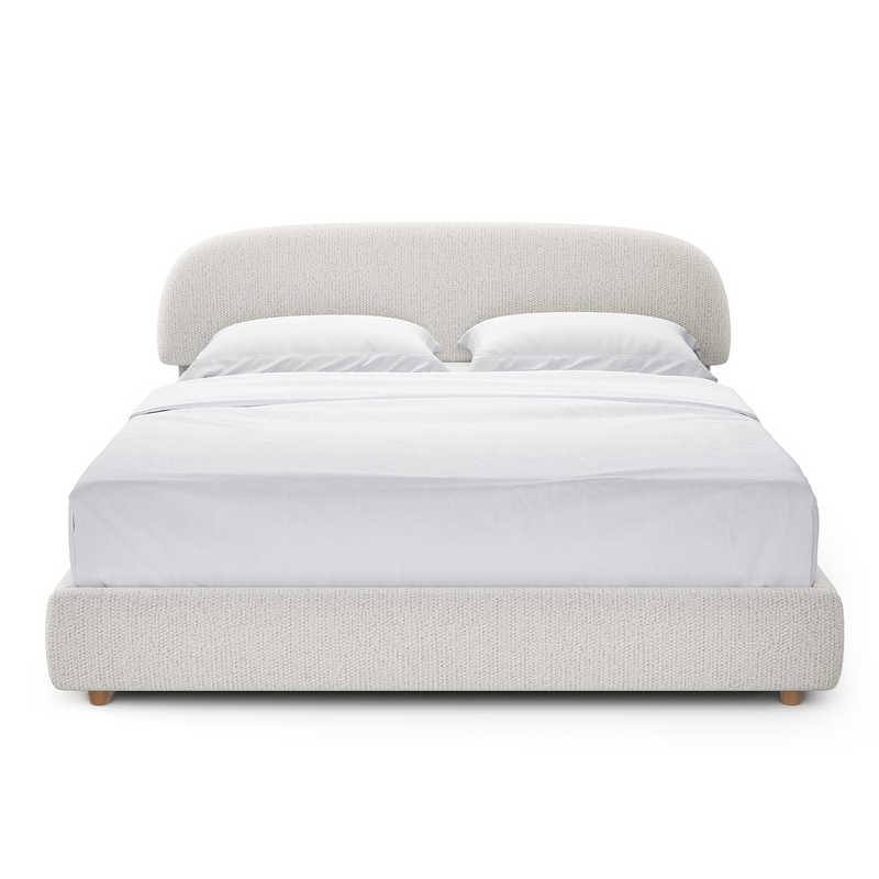 Light gray upholstered bed with a broad rounded headboard and low padded footboard, shown from the front