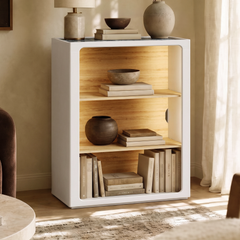 Tall narrow pale wood cabinet with an open front and two interior shelves beside a curtain