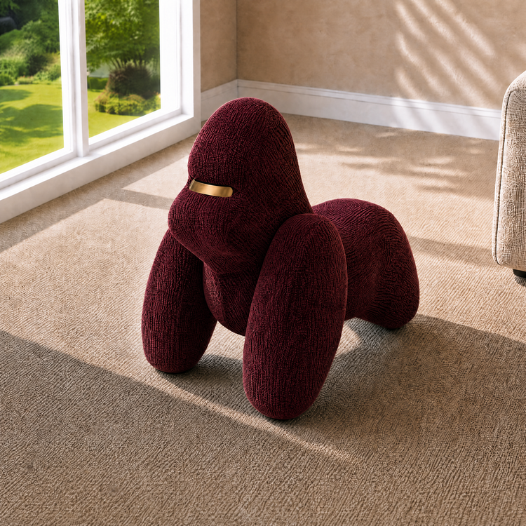 Burgundy sculptural upholstered seat with rounded animal-like forms, Gold-tone accent spans the front of its head