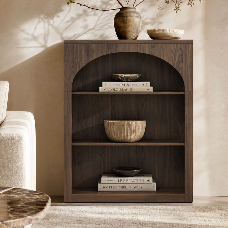 Dark wood-grain bookcase with an arched opening and three display compartments holding books and bowls