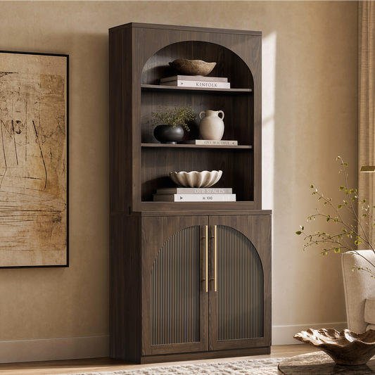 Tall dark wood-grain bookcase with arched open shelving above fluted double doors and gold-tone handles