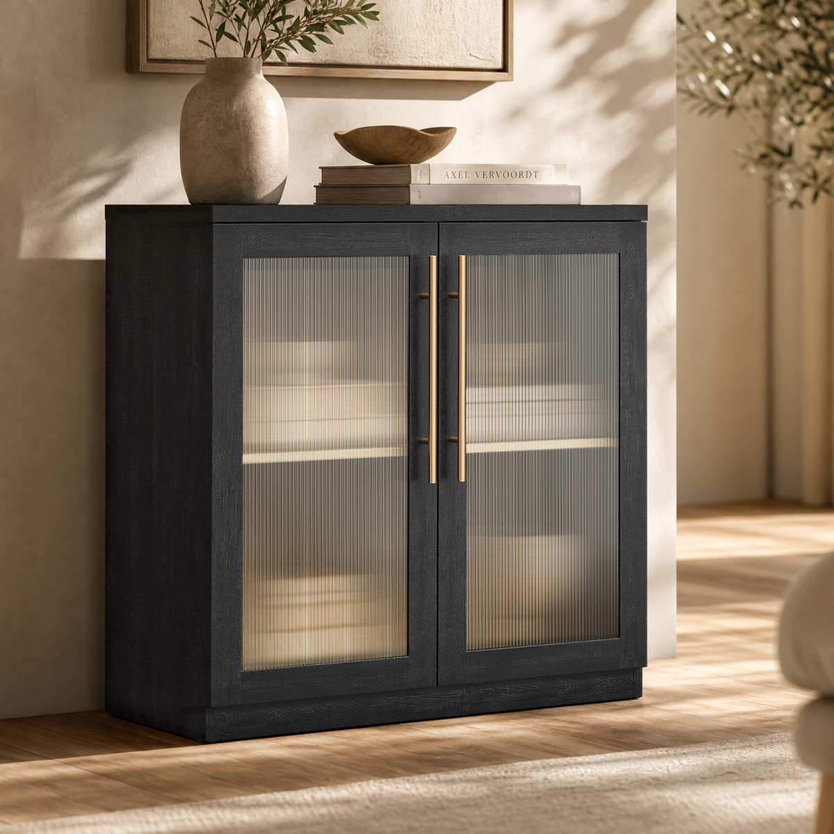 Black cabinet with ribbed translucent double doors and long gold-tone handles, with pale dishes visible inside