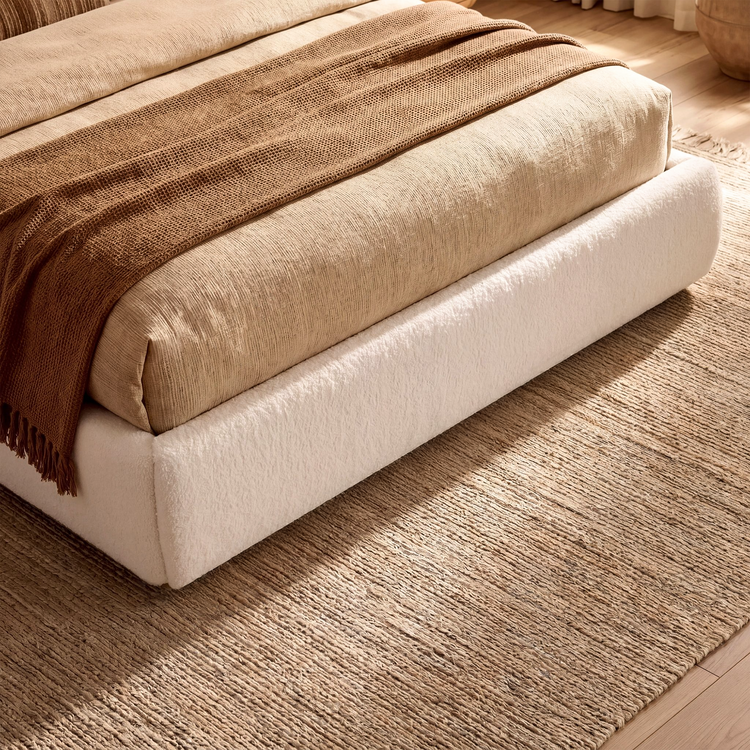 The footboard has a soft cream textured upholstery appearance