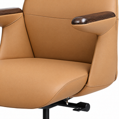 Close-up of a tan upholstered chair with light stitching, dark brown wood-grain armrest tops, and a black adjustment lever beneath the seat.