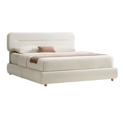 Cream upholstered bed with a rounded rectangular headboard, short tapered feet, white bedding, a pink accent pillow and a brown fringed throw across the foot.
