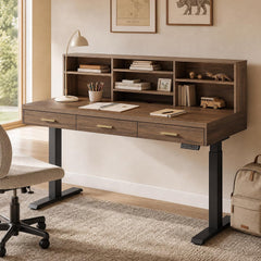 A dark wood desk with three drawers and open shelving stands on black adjustable legs in a study, with books, stationery, a lamp, and small ornaments arranged on it.