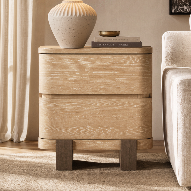 The cabinet has two stacked drawers with broad curved fronts, Four short block feet support the cabinet