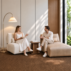 Two people converse while seated in a bright modern living room.