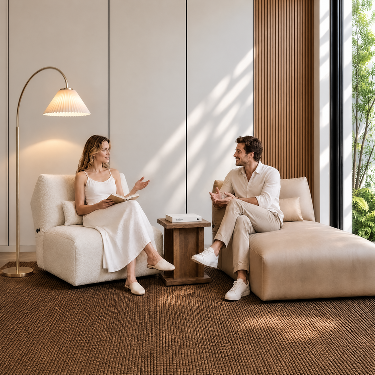 Two people converse while seated in a bright modern living room.