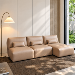 Tan three-seat modular sofa with matching lumbar pillows in a bright modern room
