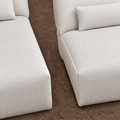 Close-up of cream textured upholstered seating with matching cushions.