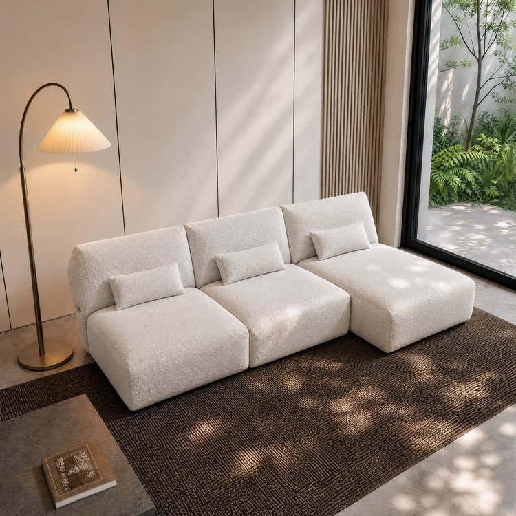 White three-section modular sofa with chaise and matching lumbar cushions.