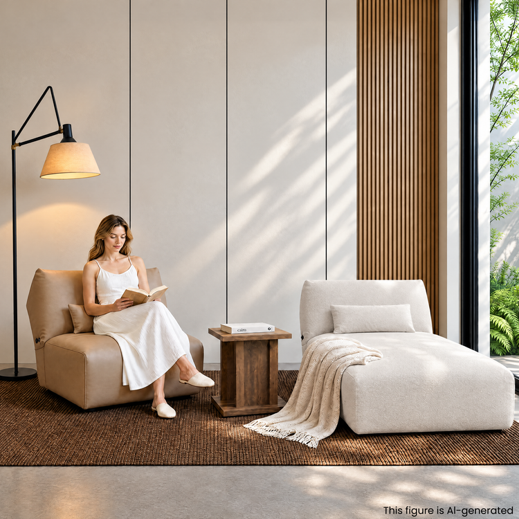 Woman reading in a tan lounge chair beside a white chaise in a modern room.