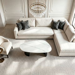 Overhead view of a white sectional sofa arranged around a sculptural white coffee table