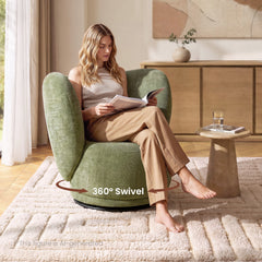 Woman reads while seated in a green rounded armchair